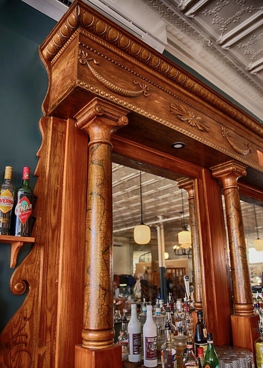 A carved wooden column framing the mirror of the back bar